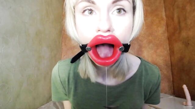 Zooming in red lips open mouth gag for dildo-blowjob.