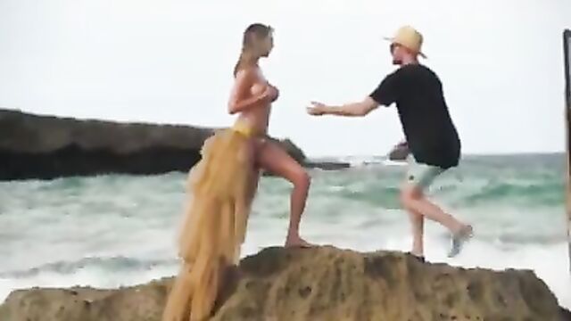 Kate Upton on the beach, washed of rock while topless