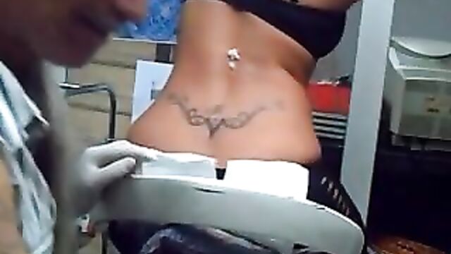 Sexy blonde getting tramp stamp tattoo