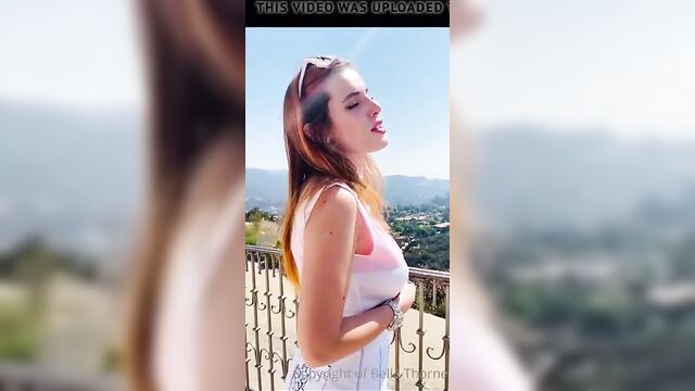 Bella Thorne taking on a balcony taking her top off