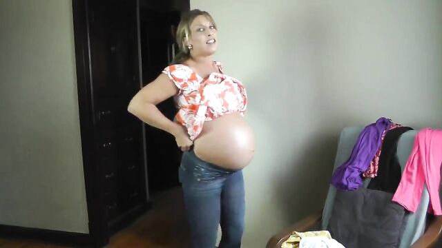 Sexy pregnant girl trying on dresses