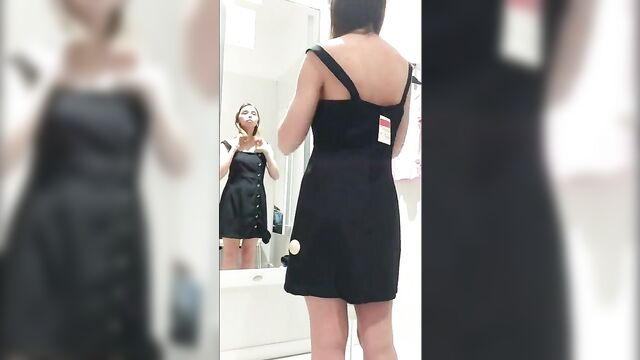 My girlfriend is in the fitting room trying on clothes in the store