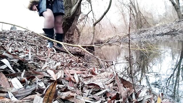 Curvy MILF pissing on the riverside