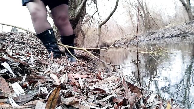 Curvy MILF pissing on the riverside