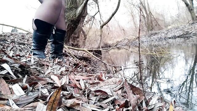 Curvy MILF pissing on the riverside