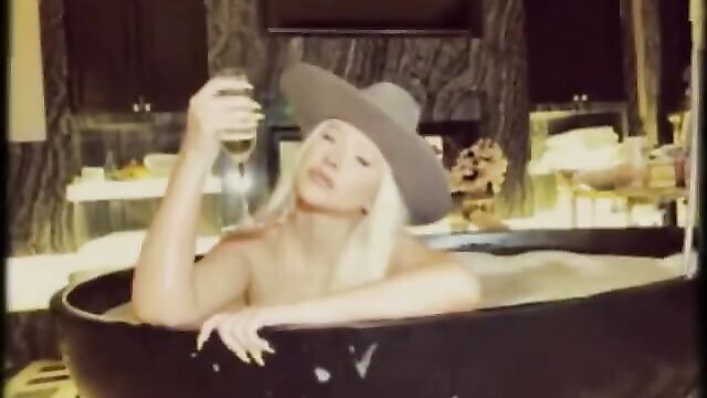 Christina Aguilera in bathtup wearing a cowboy hat