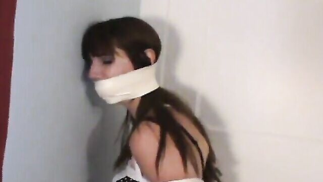 Slave girl kneels tied and gagged in corner for her Master