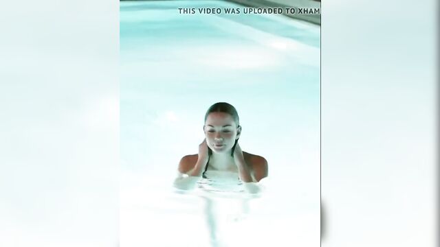 Maia Mitchell emerging from a pool in a black bikini
