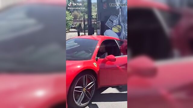 Saxon Sharbino posing in a red car